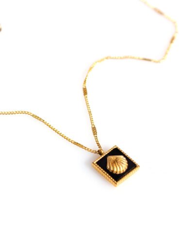 golden necklace whith a golden shell in black backround